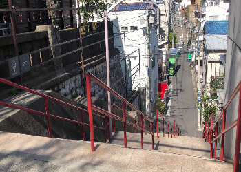 Die berühmte Treppe aus dem Anime 'Your Name' in Tokyo, aufgenommen während einer sonnigen Szene.